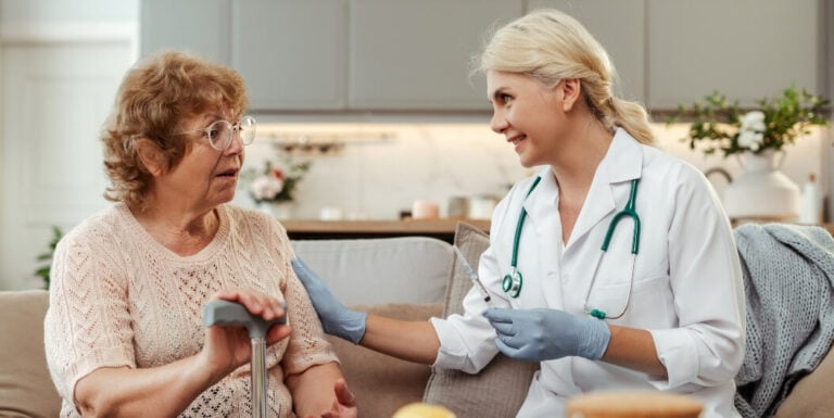 Female Nurse Administering an Injection to an Elderly Woman at an Assisted Living Facility